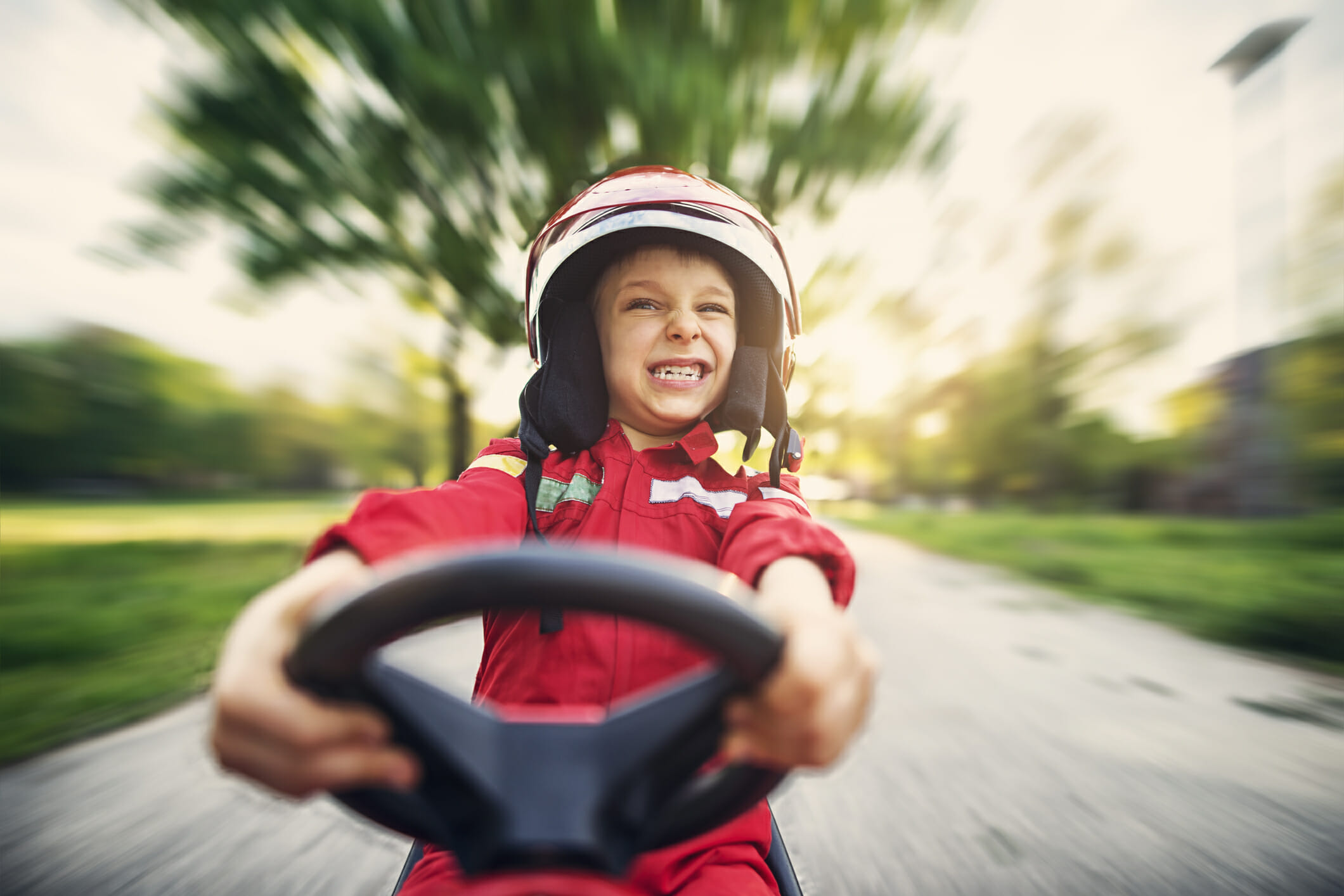 Portrait of little boy driving fast his toy car United